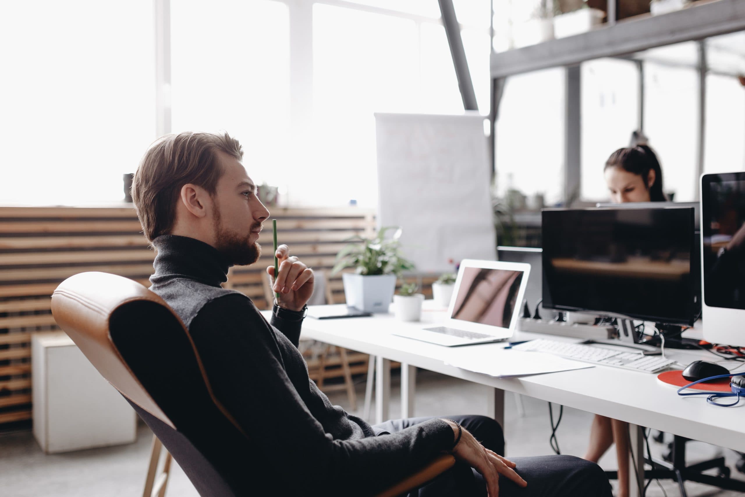 Zwei IT-Mitarbeiter im Hemd analysieren gemeinsam Code am Bildschirm im Büro