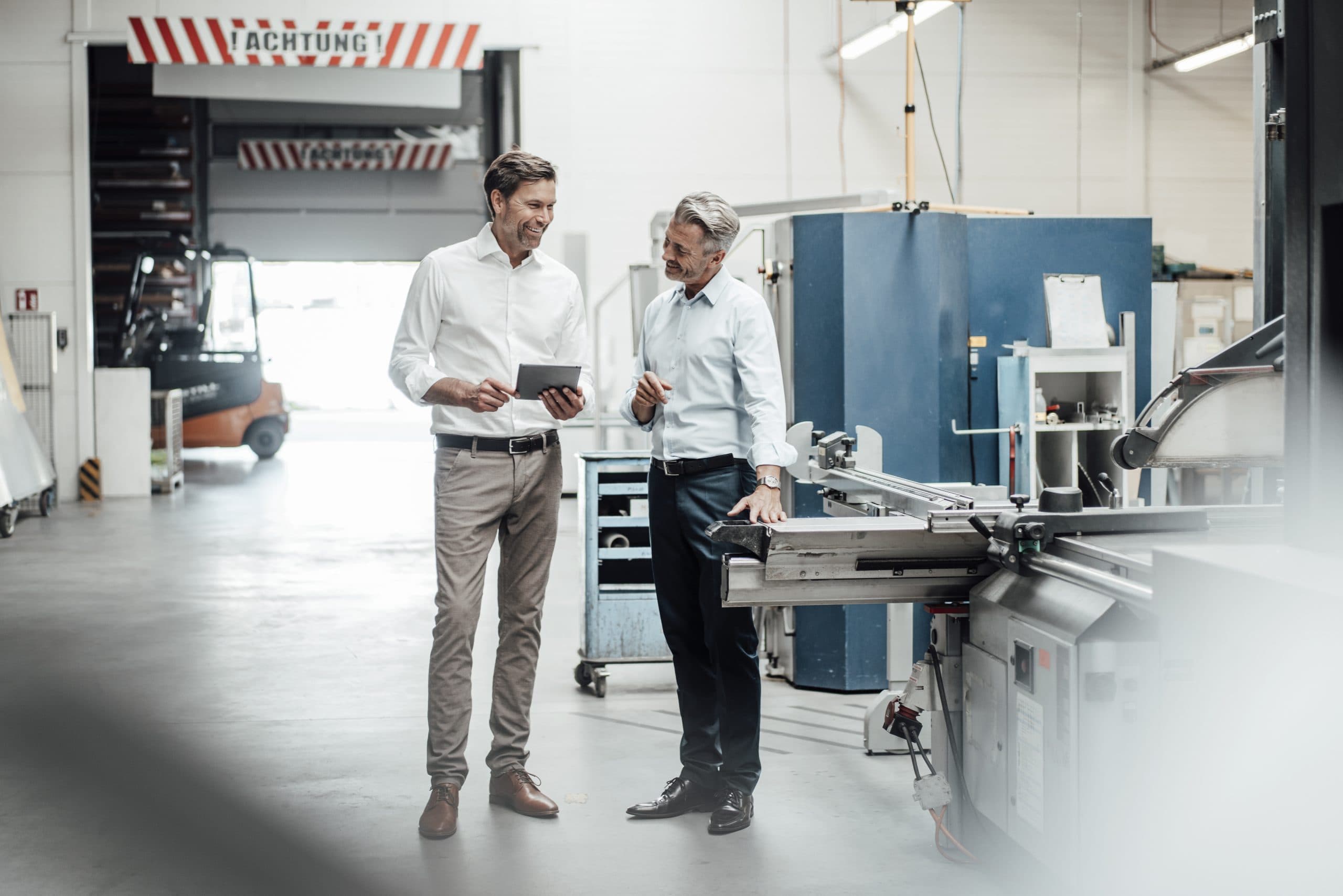 Ingenieur mit Tablet in einer Produktionshalle eines Industriebetriebs