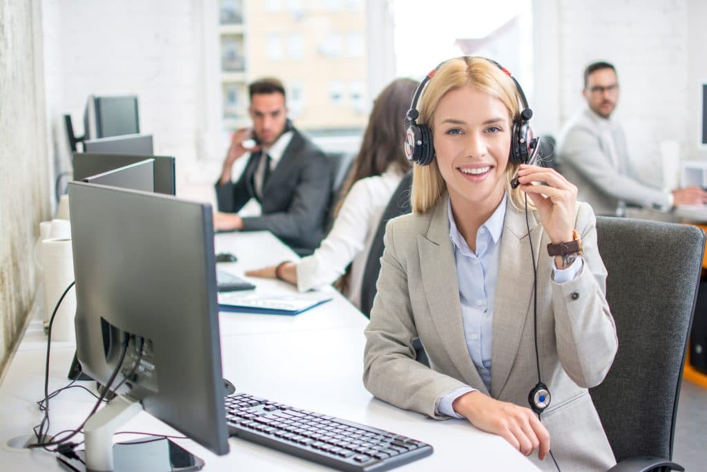 portrait smiling female customer service representative with colleagues working office 1024x683